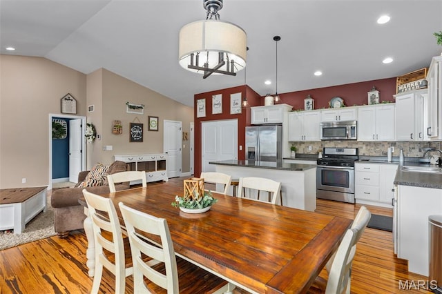 1145 Nassau Dr, Edwardsville, IL 62025 - dining space featuring vaulted ceiling, light wood-type flooring, and recessed lighting