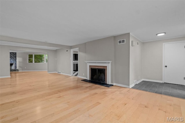 7315 Ahern Ave, University City, MO 63130 - unfurnished living room featuring a fireplace with raised hearth and wood finished floors