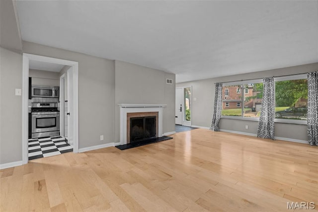 7315 Ahern Ave, University City, MO 63130 - unfurnished living room featuring wood finished floors and a fireplace with raised hearth