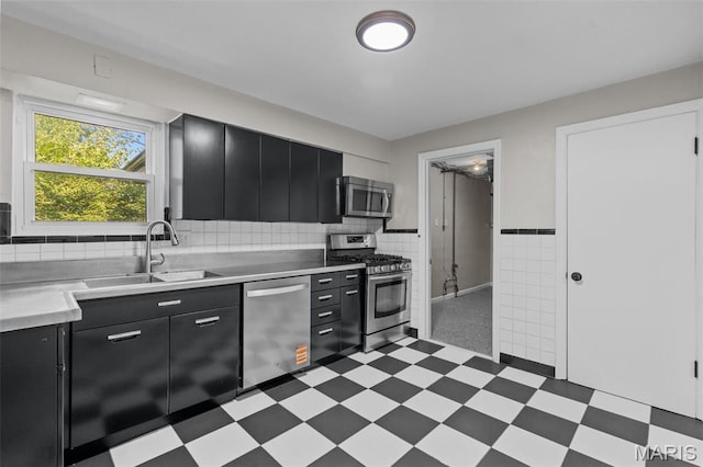 7315 Ahern Ave, University City, MO 63130 - kitchen with stainless steel appliances, dark cabinetry, light flooring, light countertops, and tile walls