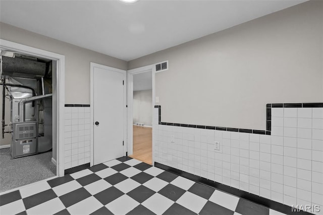 7315 Ahern Ave, University City, MO 63130 - unfurnished bedroom featuring tile walls, tile patterned floors, wainscoting, and heating unit