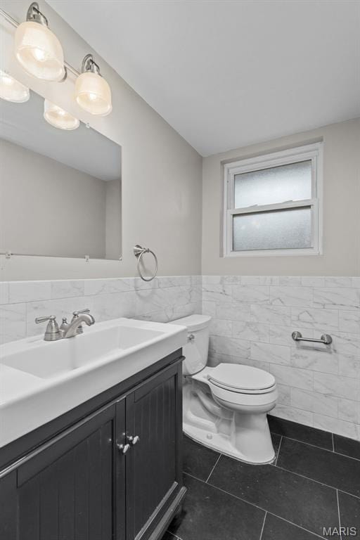 7315 Ahern Ave, University City, MO 63130 - bathroom featuring tile walls, tile patterned floors, vanity, and a wainscoted wall