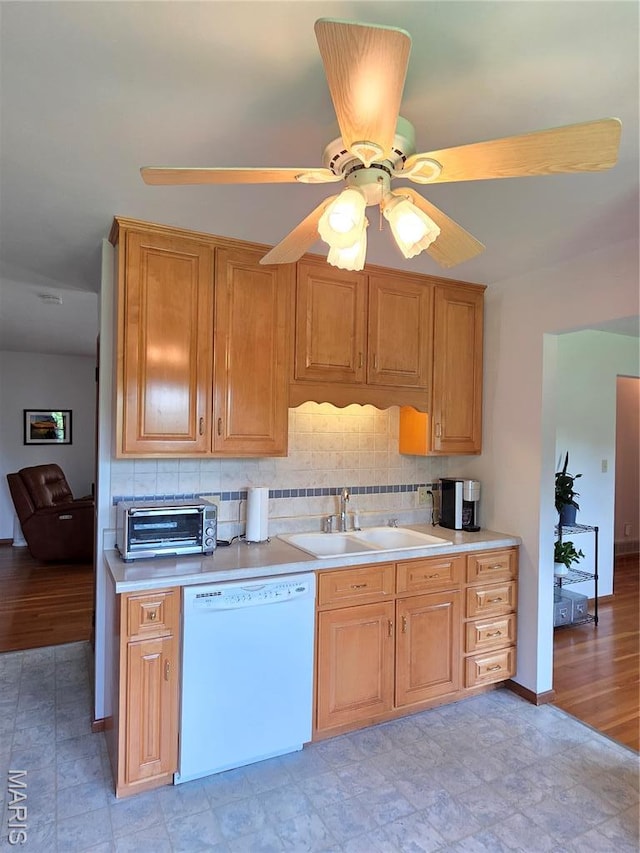 320 W 6th St, Washington, MO 63090 - kitchen featuring white dishwasher, light countertops, tasteful backsplash, and ceiling fan
