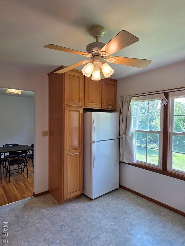 320 W 6th St, Washington, MO 63090 - kitchen with freestanding refrigerator, brown cabinetry, and ceiling fan