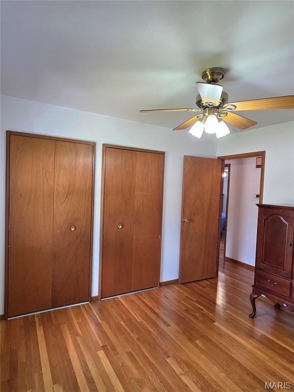 320 W 6th St, Washington, MO 63090 - unfurnished bedroom featuring multiple closets, wood finished floors, and ceiling fan