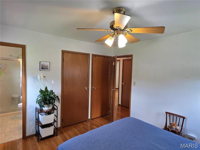320 W 6th St, Washington, MO 63090 - bedroom with multiple closets, wood finished floors, connected bathroom, and ceiling fan