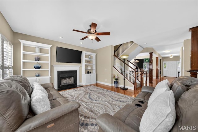 1304 Forest Way, Wentzville, MO 63385 - living room with ornate columns, stairway, a ceiling fan, built in features, and a fireplace