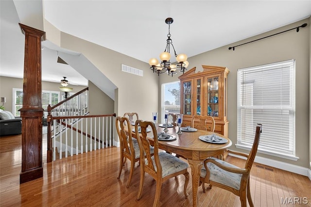 1304 Forest Way, Wentzville, MO 63385 - dining space with light wood-style flooring, a chandelier, a ceiling fan, ornate columns, and stairs