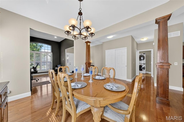 1304 Forest Way, Wentzville, MO 63385 - dining space with stacked washer / dryer, ornate columns, light wood-style flooring, and a chandelier