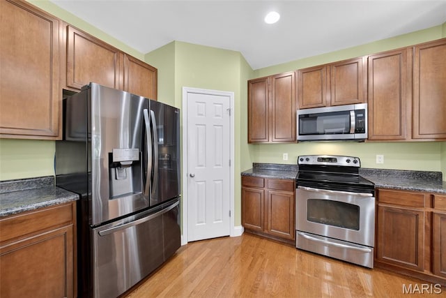 1304 Forest Way, Wentzville, MO 63385 - kitchen with stainless steel appliances, dark countertops, light wood-style flooring, brown cabinets, and recessed lighting