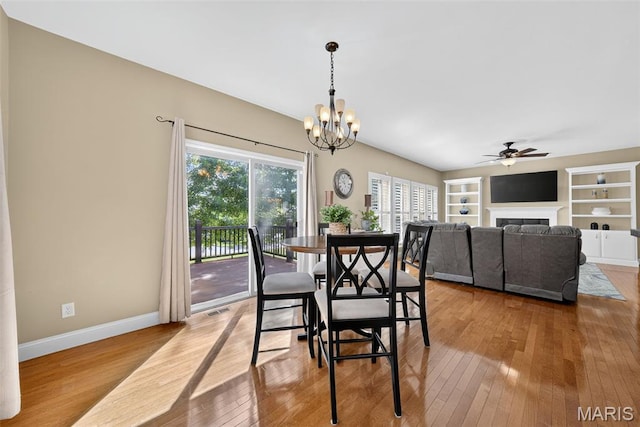 1304 Forest Way, Wentzville, MO 63385 - dining area featuring ceiling fan, hardwood / wood-style floors, a fireplace, built in features, and a chandelier