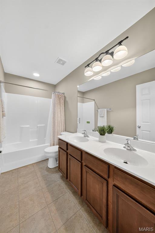 1304 Forest Way, Wentzville, MO 63385 - full bathroom with double vanity, shower / bath combination with curtain, and tile patterned floors