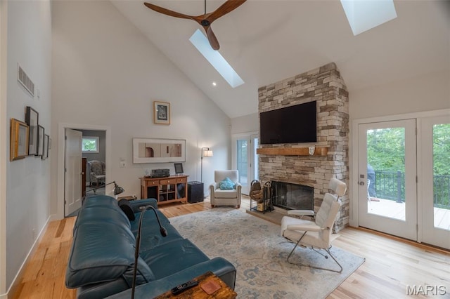 2740 Tyrol View Ct, Innsbrook, MO 63390 - living area with a skylight, high vaulted ceiling, a fireplace, light wood-style flooring, and a ceiling fan