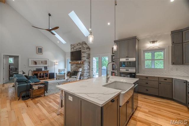 2740 Tyrol View Ct, Innsbrook, MO 63390 - kitchen with high vaulted ceiling, a skylight, open floor plan, light wood-style floors, and plenty of natural light