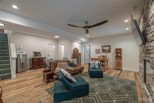 2740 Tyrol View Ct, Innsbrook, MO 63390 - living area with stairway, a stone fireplace, light wood-type flooring, recessed lighting, and a ceiling fan
