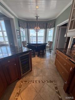807B Wind Rivers Dr, Grafton, IL 62037 - kitchen featuring wine cooler, dark countertops, a chandelier, light tile patterned floors, and crown molding