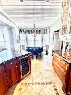 807B Wind Rivers Dr, Grafton, IL 62037 - kitchen featuring wine cooler, light tile patterned floors, glass insert cabinets, and a chandelier
