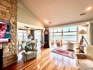 807B Wind Rivers Dr, Grafton, IL 62037 - living area featuring a fireplace, wood finished floors, a water view, and high vaulted ceiling