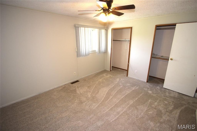 420 Lake Dr, Bonne Terre, MO 63628 - unfurnished bedroom with multiple closets, carpet, a textured ceiling, and a ceiling fan
