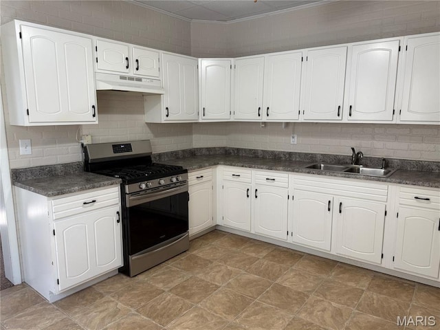 3313 Saint Charles St, Hannibal, MO 63401 - kitchen with stainless steel gas range oven, under cabinet range hood, crown molding, and dark countertops