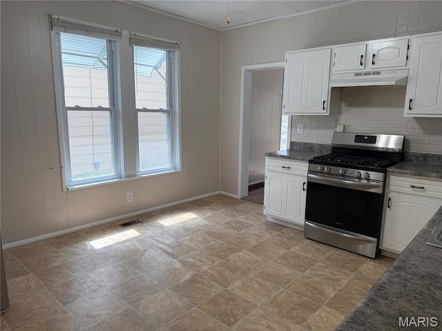 3313 Saint Charles St, Hannibal, MO 63401 - kitchen featuring stainless steel gas range, under cabinet range hood, dark countertops, white cabinets, and decorative backsplash