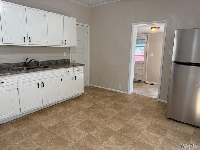 3313 Saint Charles St, Hannibal, MO 63401 - kitchen featuring freestanding refrigerator, dark countertops, white cabinetry, and crown molding