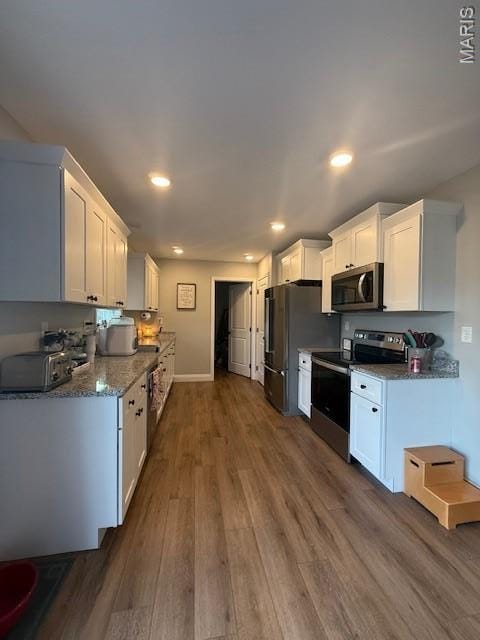 2519 Cortland Dr, Jackson, MO 63755 - kitchen featuring appliances with stainless steel finishes, wood finished floors, white cabinetry, recessed lighting, and stone counters