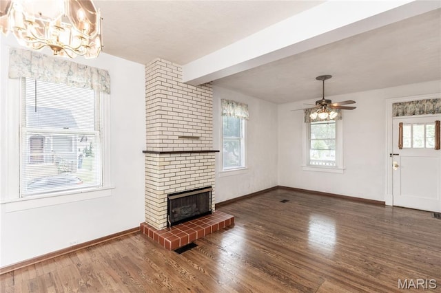 711 Erskine Ave, Lemay Township, MO 63125 - unfurnished living room with wood finished floors, a chandelier, a brick fireplace, a ceiling fan, and beam ceiling