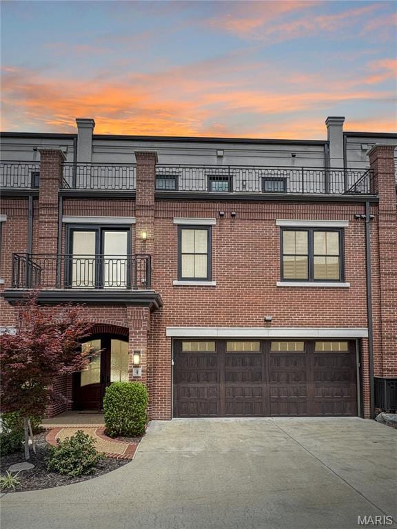 4 Market St, Washington, MO 63090 - view of front of home with an attached garage, driveway, brick siding, and a balcony