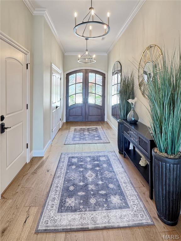 4 Market St, Washington, MO 63090 - foyer entrance with french doors, wood finished floors, ornamental molding, and a chandelier