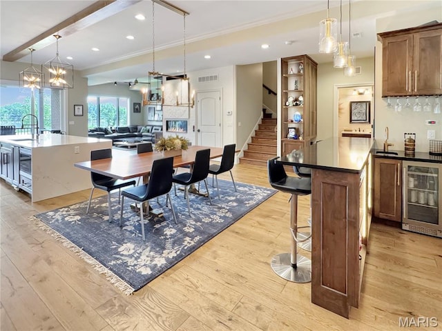 4 Market St, Washington, MO 63090 - dining area with beverage cooler, light wood finished floors, stairs, ornamental molding, and a dry bar