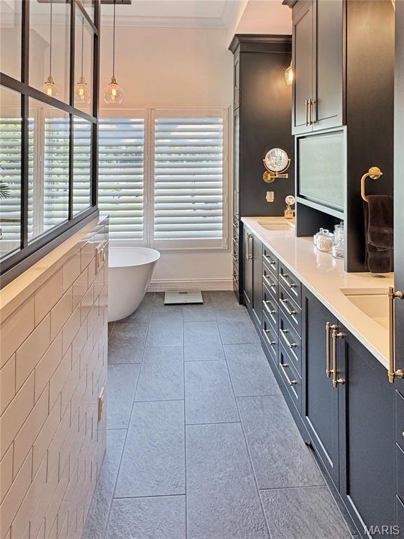 4 Market St, Washington, MO 63090 - bathroom with double vanity, a freestanding bath, tile patterned flooring, and ornamental molding