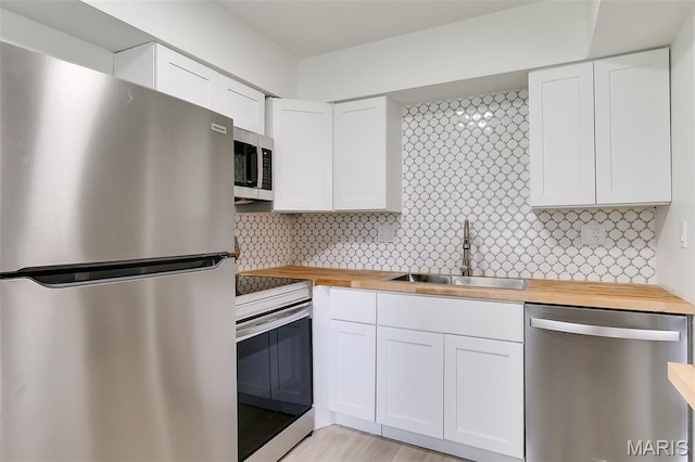 8733 Sieloff Dr Unit C, Hazelwood, MO 63042 - kitchen with wood counters, stainless steel appliances, and white cabinetry