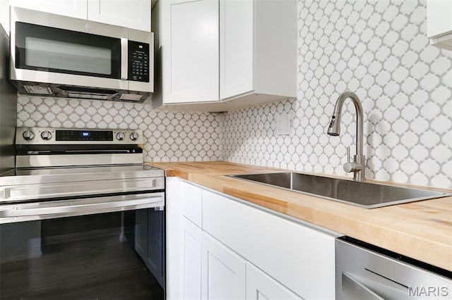8733 Sieloff Dr Unit C, Hazelwood, MO 63042 - kitchen with butcher block countertops, appliances with stainless steel finishes, white cabinetry, and tasteful backsplash