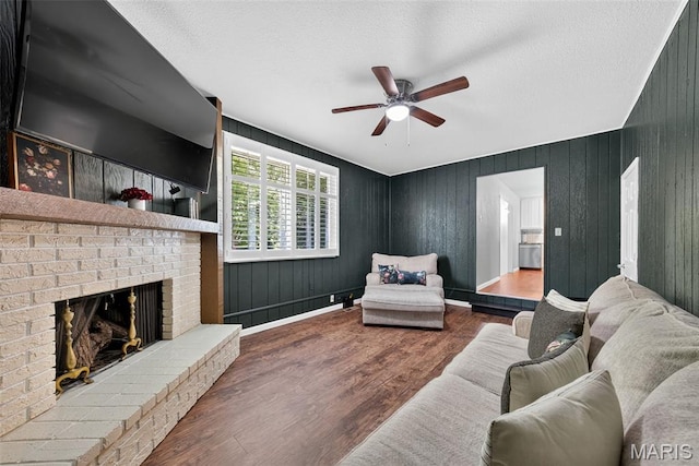 1002 Arlington Dr, Saint Charles, MO 63303 - living room featuring a ceiling fan, a fireplace, wood finished floors, and a textured ceiling