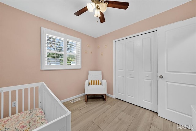 1002 Arlington Dr, Saint Charles, MO 63303 - bedroom with light wood-type flooring, a closet, a crib, and a ceiling fan