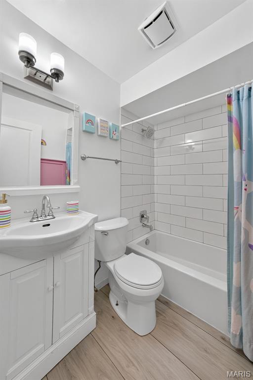 1002 Arlington Dr, Saint Charles, MO 63303 - bathroom with vanity, wood finished floors, and shower / bath combo