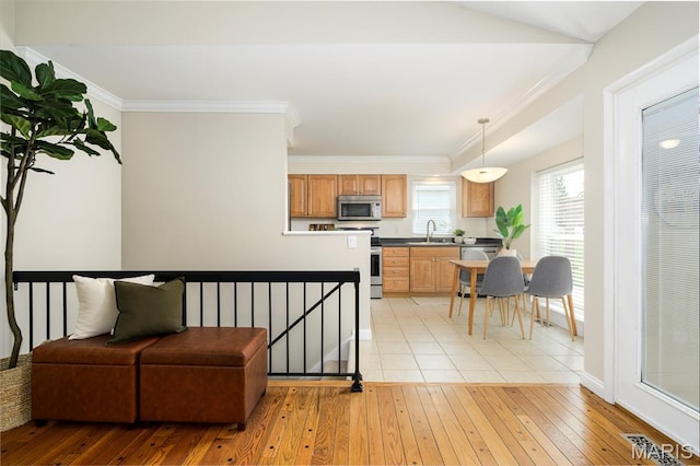 1730 Blakefield Ter, Manchester, MO 63021 - kitchen with light wood-style flooring, stainless steel microwave, ornamental molding, hanging light fixtures, and dishwasher