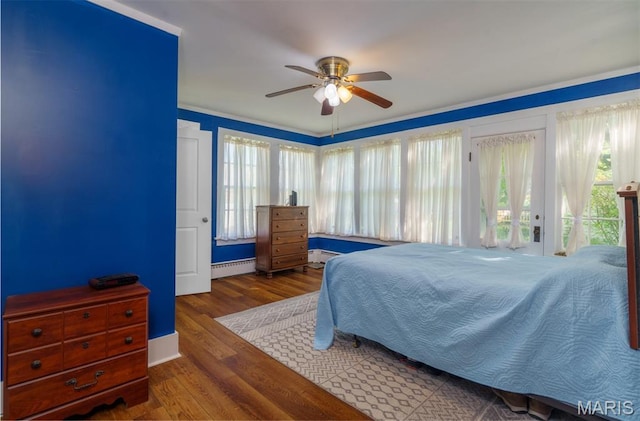 131 W James Blvd, St James, MO 65559 - bedroom with a baseboard heating unit, wood finished floors, and a ceiling fan