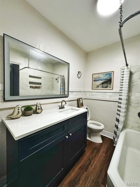 1604 Quendo Ave, Saint Louis, MO 63130 - full bath featuring wood finished floors, vanity, shower / bath combination with curtain, and wainscoting