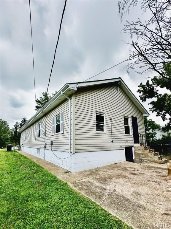 1604 Quendo Ave, Saint Louis, MO 63130 - view of side of home featuring a lawn and a patio