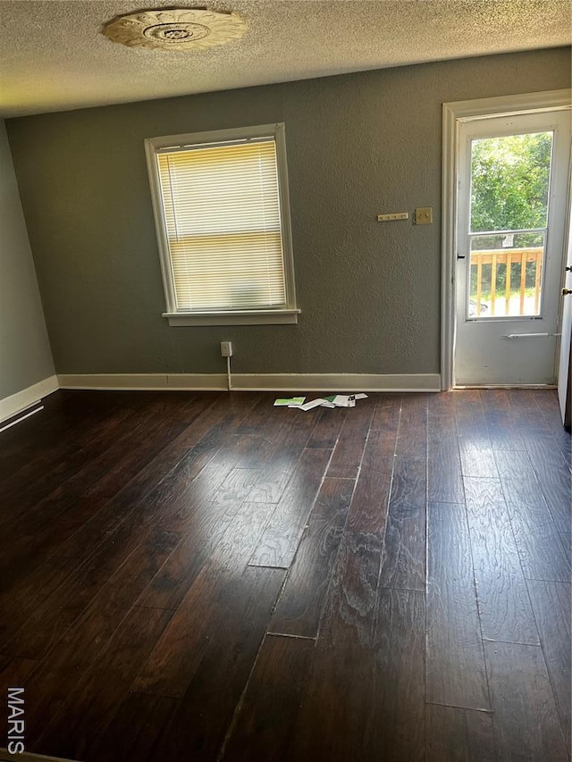 5209 College Ave, Jennings, MO 63136 - empty room with dark wood-style floors and a textured ceiling