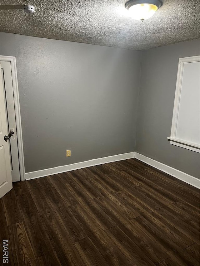 5209 College Ave, Jennings, MO 63136 - unfurnished room with a smoke detector, dark wood finished floors, and a textured ceiling