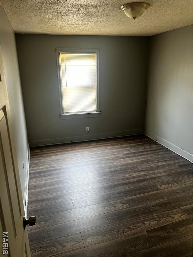 5209 College Ave, Jennings, MO 63136 - empty room with dark wood-style floors and a textured ceiling