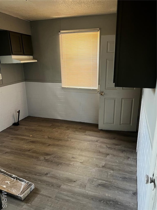 5209 College Ave, Jennings, MO 63136 - unfurnished room featuring a wainscoted wall, wood finished floors, concrete block wall, and a textured ceiling