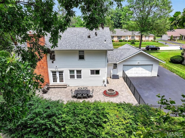 538 Kenilworth Ln, Ballwin, MO 63011 - back of house featuring a shingled roof, a garage, a fire pit, driveway, and a patio