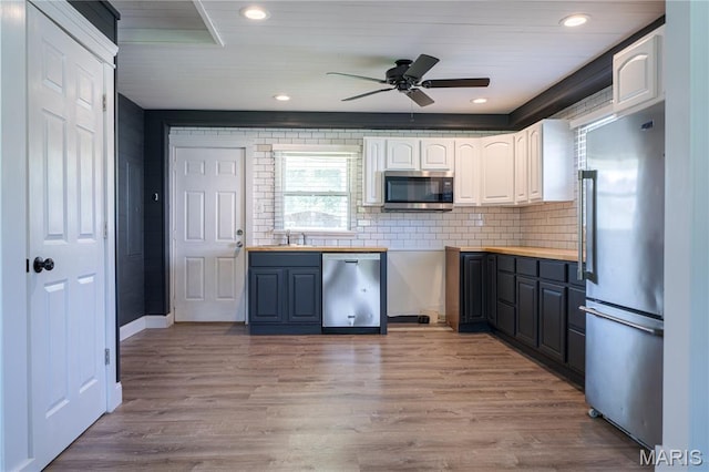 2004 Cottage Ave, Granite City, IL 62040 - kitchen featuring appliances with stainless steel finishes, ceiling fan, white cabinetry, tasteful backsplash, and light wood-style floors