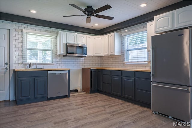 2004 Cottage Ave, Granite City, IL 62040 - kitchen with stainless steel appliances, white cabinets, ceiling fan, light wood-type flooring, and decorative backsplash