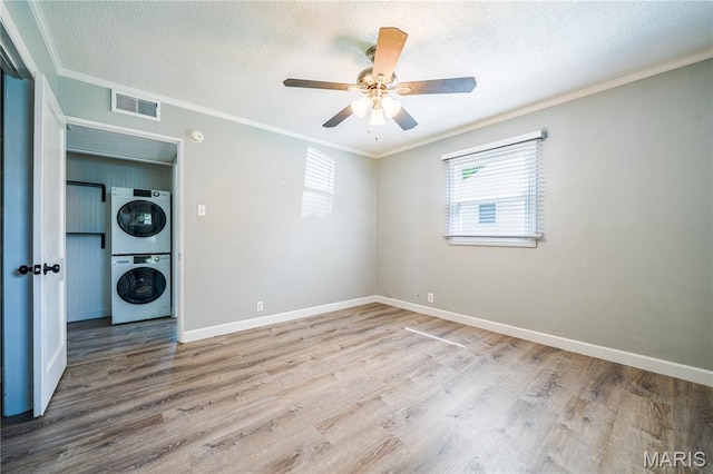 2004 Cottage Ave, Granite City, IL 62040 - empty room with stacked washer and clothes dryer, wood finished floors, a textured ceiling, a ceiling fan, and ornamental molding