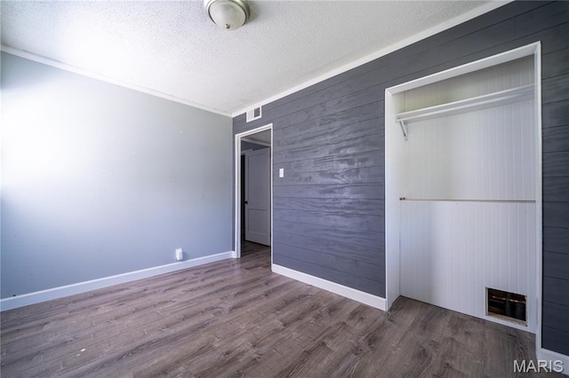 2004 Cottage Ave, Granite City, IL 62040 - unfurnished bedroom with a textured ceiling, wood finished floors, wood walls, and a closet
